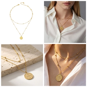 Détail du collier double rang doré avec pendentif œil maléfique sur pierre texturée