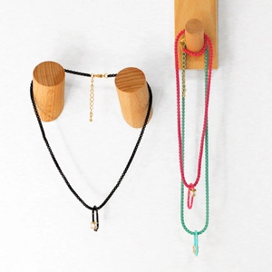 Dettaglio della collana colorata con pendente in cristallo rettangolare e catena dorata