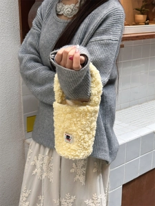 Close-up of yellow fleece plush cup sleeve bag with a cute cartoon cat patch detail