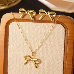 Elegant gold bow jewelry set featuring a polished necklace and matching stud earrings