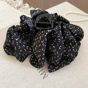 Détail de la grande pince à cheveux en tissu noir avec imprimés lune et ressort