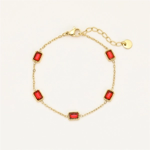 Detailed macro view of gold plated bracelet with five rectangular red zircon gemstones