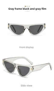 Close-up of cat-eye sunglasses with transparent grey frames and golden metal hinges