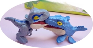 Macro detail of two cute dinosaur bite finger toys with realistic snapping mechanical jaws