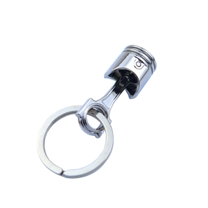 Creative silver metal keychain featuring a piston and connecting rod design on white background