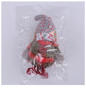 Close-up of a Christmas gnome doll with a red knit hat in clear plastic packaging