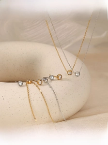 Detail of elegant gold and silver jewelry set featuring round cubic zirconia on white display
