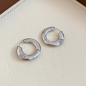 Detail view of silver tiered hoop earrings with sparkling heart-shaped zircon stones