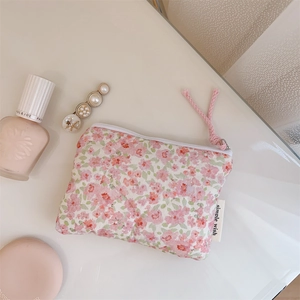 Detailed close-up of a pink floral quilted cotton storage pouch for makeup and small items