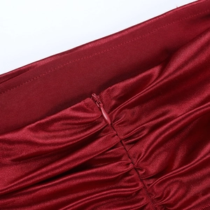 Macro detail of dark red satin dress with invisible zipper and elegant pleating