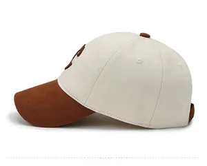 Detailed side view of beige cotton baseball cap with dark brown brim and 3D letter embroidery