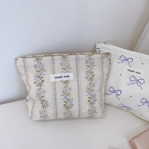 Détail de motifs fleurs et nœuds sur de petites trousses de maquillage en coton
