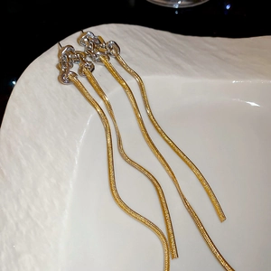 Gros plan sur les boucles d'oreilles pampilles en chaîne serpent or et argent