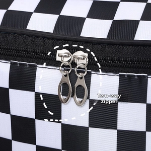 Close-up of the smooth two-way metal zipper on checkerboard travel makeup bag