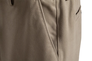 Detailed view of beige corduroy fabric texture and reinforced pocket stitching on trousers