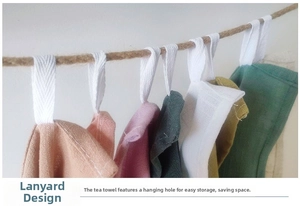 Detail of colorful cotton tea towels with woven hanging loops on a rustic jute rope