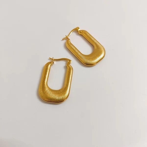 Detailed top view of 18k gold plated U-shaped earrings with fine horizontal textures