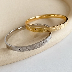 Detailed view of gold and silver metal bangles with geometric engraved textures