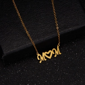 Detail of gold Mama necklace with a heart-shaped letter O on black leather jewelry box