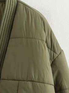 Detailaufnahme der armee-grünen Steppjacke mit geripptem Kragen und Schulterpartie