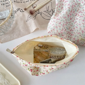 Internal view of floral canvas makeup bag showing ample storage for brushes and bottles