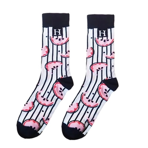 Détail de chaussettes à rayures noires et blanches avec motifs de fruits roses et lettre H