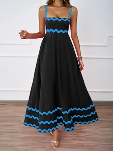 Detail of blue wavy trim on a black maxi dress with elegant high waist and full hem