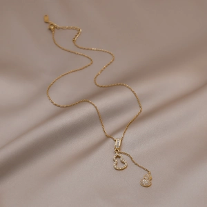 Élégant collier en acier inoxydable doré avec doubles pendentifs Wu Lou creux et cristaux blancs