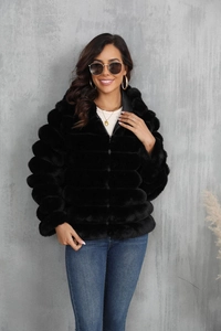 Detail shot of black faux fur jacket with zip closure and plush texture on model