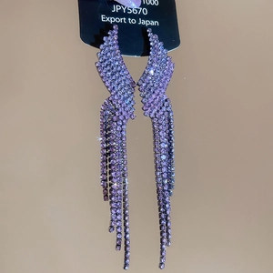 Macro view of blue butterfly wing drop earrings with long rhinestone tassels