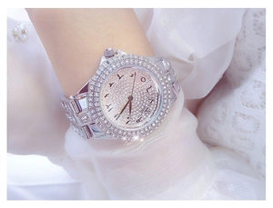 Gros plan d'une montre de luxe argentée pour femme ornée de cristaux et chiffres arabes