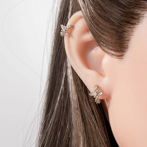French retro silver hollow cross earrings with sparkling zircons worn on earlobe