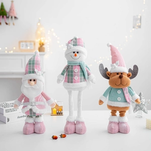 Close-up of pastel pink and mint green Christmas plush dolls with plaid details