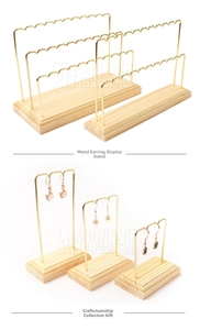 Detail of wooden base jewelry stands with gold metal hooks for earrings and rings