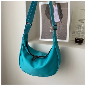 Detail of teal nylon crescent crossbody bag with adjustable wide strap and smooth zipper