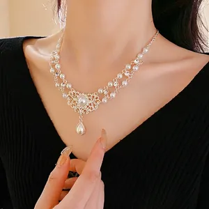 Luxurious double-layer necklace featuring teardrop pearls and vintage openwork pendants