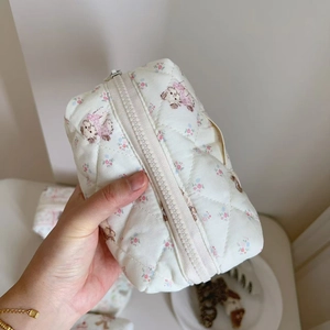 Detailed macro view of quilted floral fabric with cute dog pattern and metal zipper