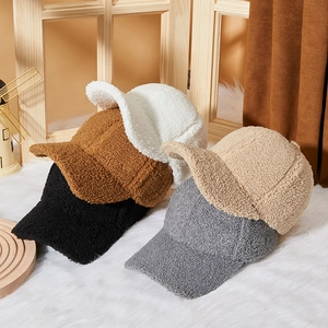 Winter faux lamb wool baseball caps in white, brown, beige, and grey on a cozy background