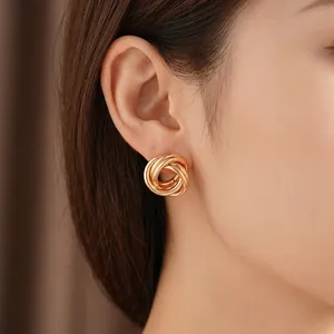 Élégantes boucles d'oreilles créoles nouées dorées avec design géométrique poli