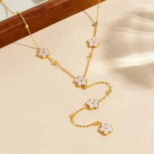 Collier en Y doré avec pendentifs fleurs blanches et finition nacre élégante