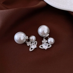 Detail of pearl earrings with crystal orb design and silver needles for women