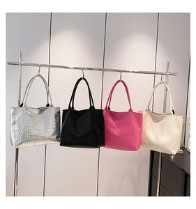 Woven tote bags displayed in silver, black, rose red, and off-white on metal hangers