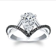 Detailed macro view of pear-cut crystal ring with V-shaped band and black stone accents
