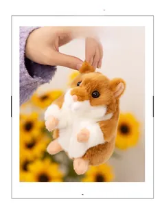 Close-up of a small plush hamster toy with soft brown fur held by hand outdoors