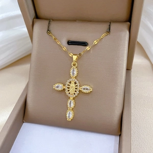 Detailed macro view of gold cross necklace with Virgin Mary relief and marquise stones