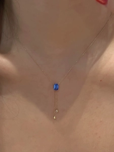 Détail du collier en or avec pierre bleue taille émeraude et pendentifs en diamant