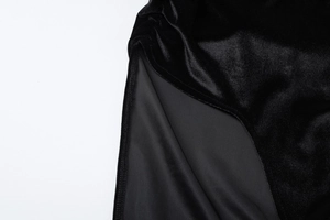 Detailansicht aus schwarzem Samt mit elegantem Seitenschlitz und weicher Stoffstruktur