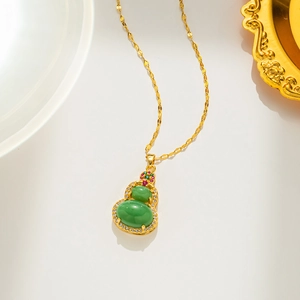 Titanium gold gourd necklace with green gemstone inlay and sparkling crystals on white background