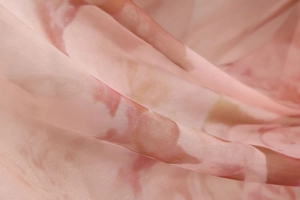 Detailed macro view of pink floral mesh fabric with sheer texture and soft drapery