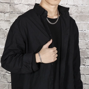 Male model wearing 8mm silver Cuban chain necklace and bracelet set over black shirt